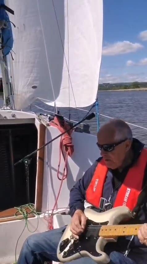 Steve Patten playing guitar aboard his previous boat, Randy Robber
